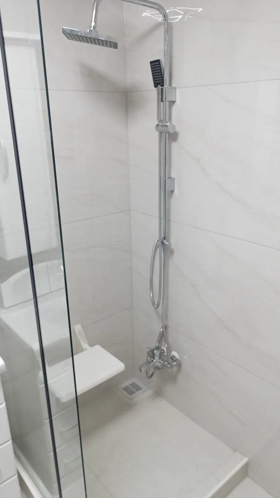 Bodengleiche Dusche mit Glasabtrennung nach der Badsanierung.