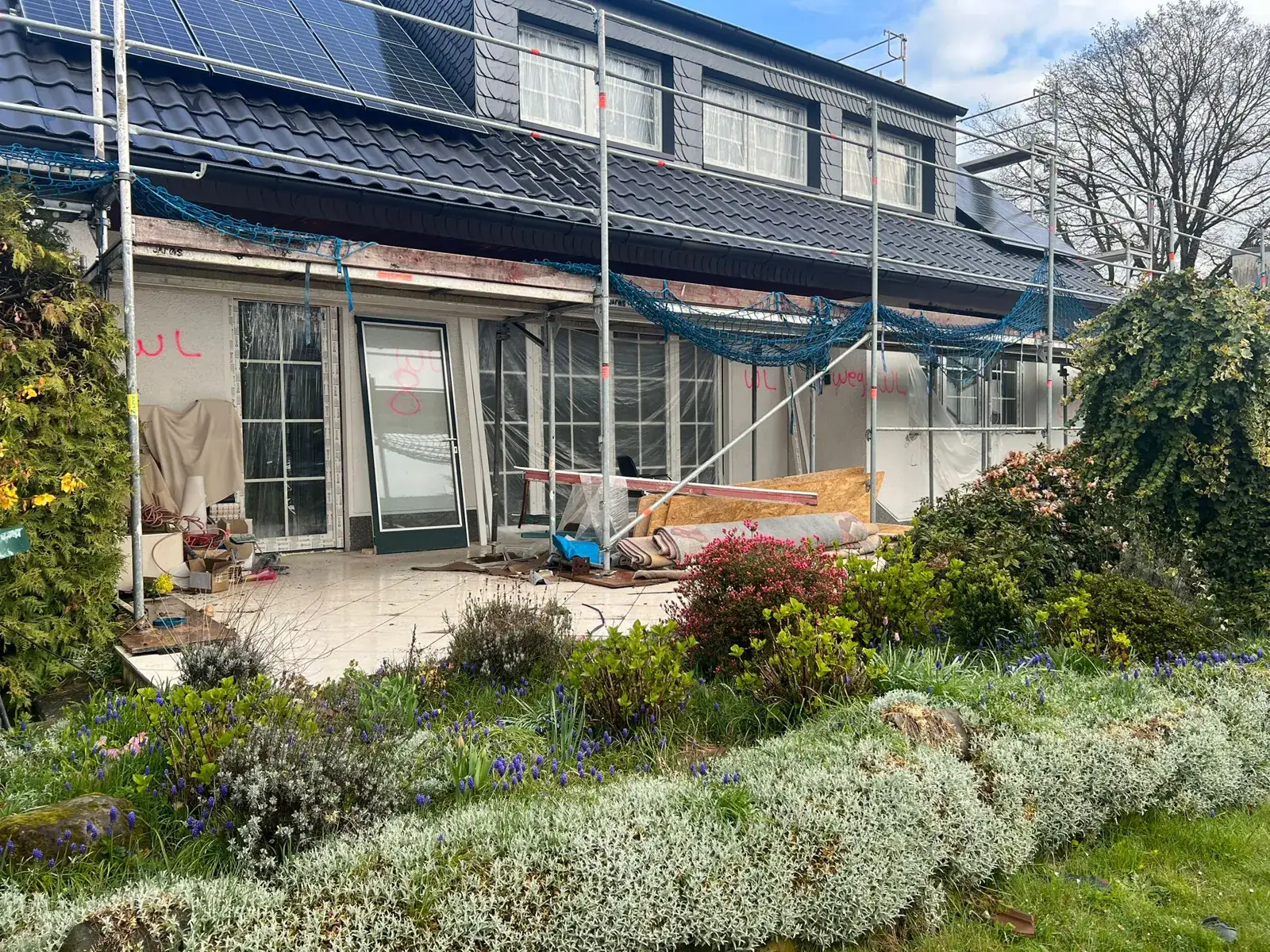 Einfamilienhaus mit Fassadenarbeiten und Photovoltaik auf dem Dach.