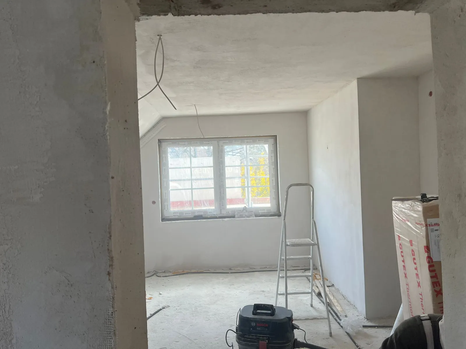 Frisch verputzter Raum im Innenausbau mit neuem Fenster.